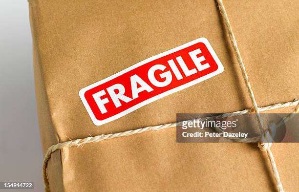 brown paper parcel with fragile sticker - fragile photos et images de collection