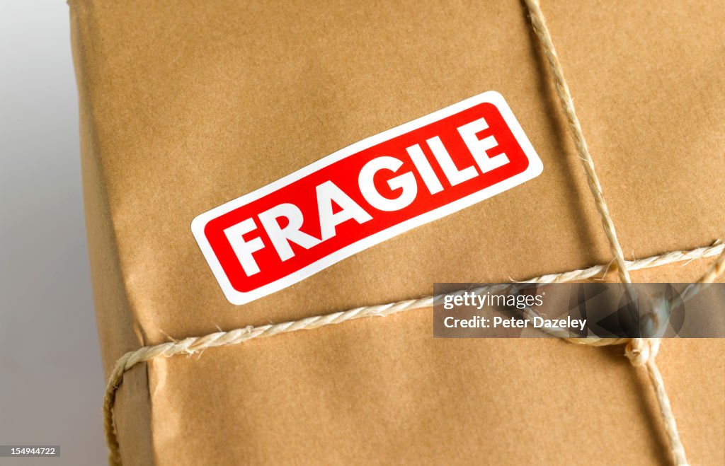Brown paper parcel with fragile sticker