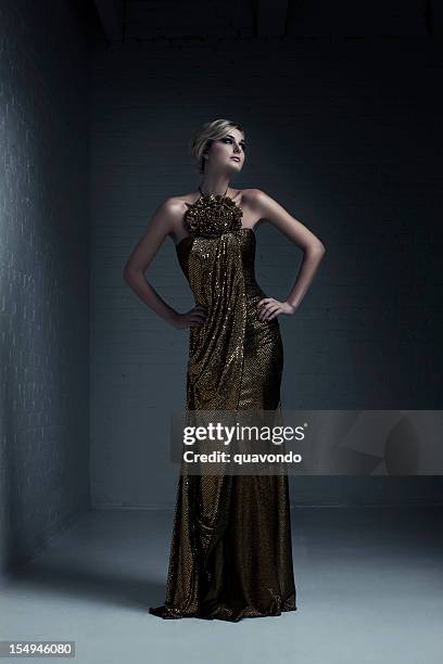 beautiful blond young woman fashion model in evening gown - lady in gold dress stock pictures, royalty-free photos & images