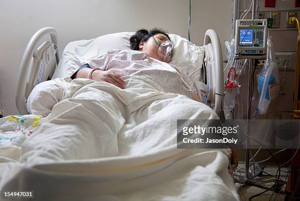 mujer en la cama de hospital - ventilador equipo respiratorio fotografías e imágenes de stock