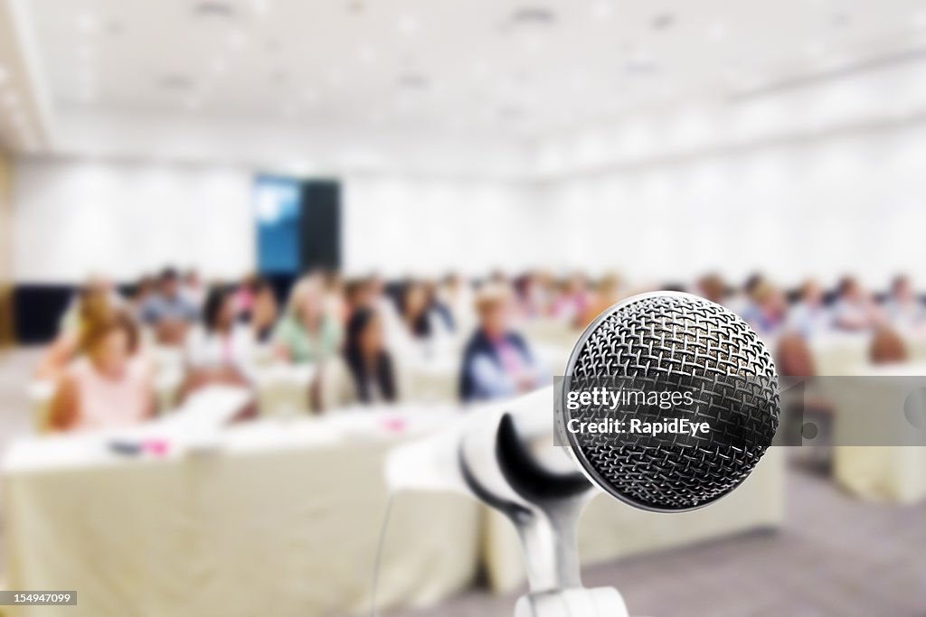 Nahaufnahme, Mikrofon, Konferenzteilnehmer im Hintergrund