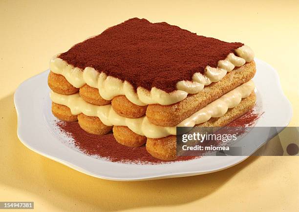 white plate of freeform tiramisu on beige surface - tiramisu stockfoto's en -beelden