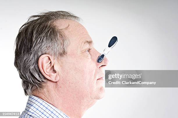businessman with peg on his nose. - pinching nose stockfoto's en -beelden