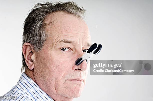 business with peg on his nose. - pinching nose stockfoto's en -beelden