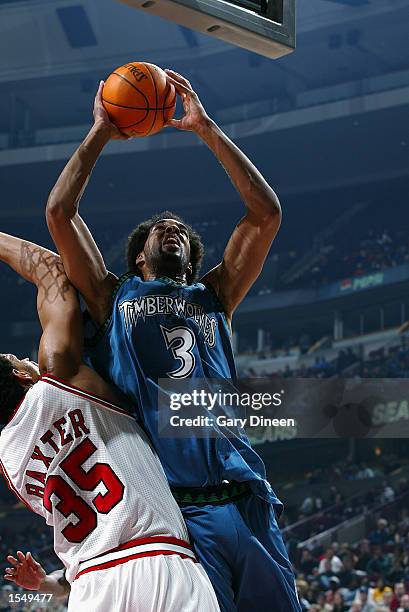 Loren Woods of the Minnesota Timberwolves goes to the basket against Lonny Baxter of the Chicago Bulls during the preseason game on October 21, 2002...