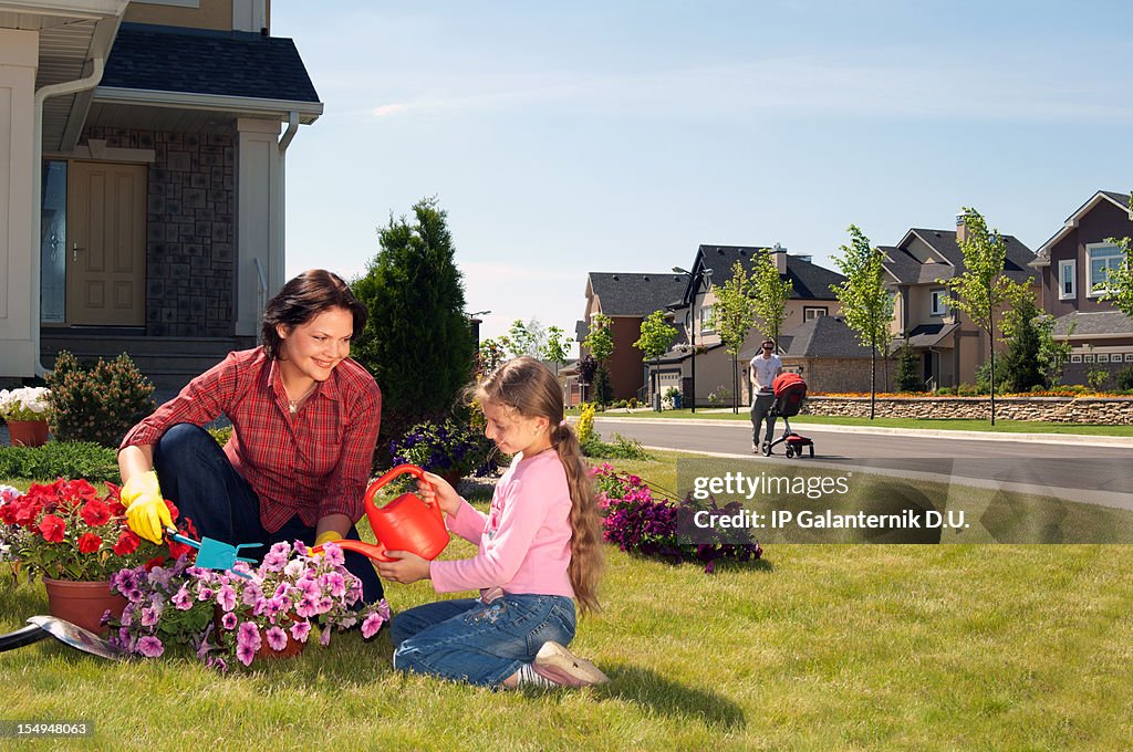 Mother and daughter gardening in yard