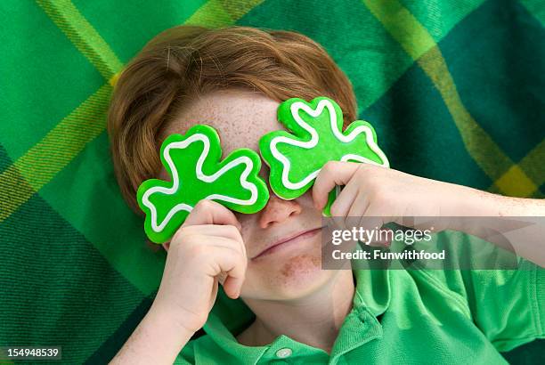 boy leprechaun, smiling irish child & st. patrick's day shamrock cookies - st patricks day 個照片及圖片檔