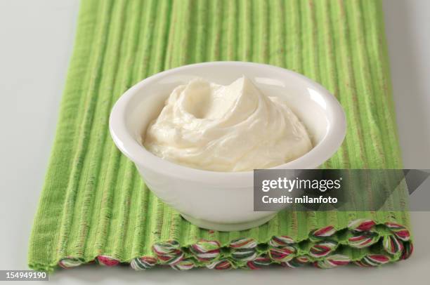 white bowl of cream cheese on green placemat - mascarpone stock pictures, royalty-free photos & images