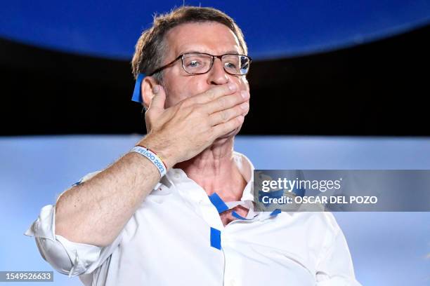 The leader and candidate of conservative Partido Popular Alberto Nunez Feijoo gestures as he addresses supporters from a balcony of the PP...