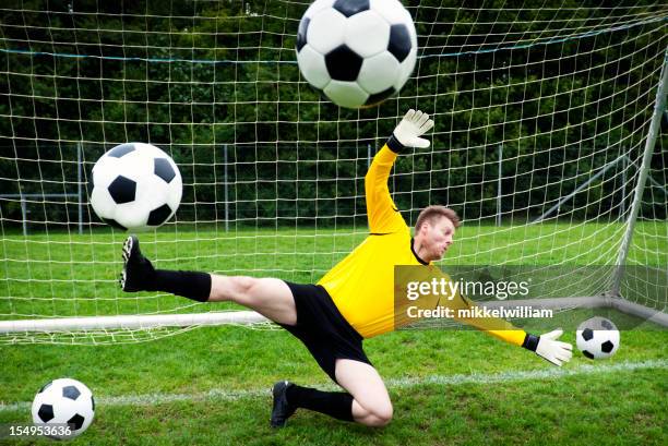goalkeeper tries hard to stop several soccer balls - try-scoring stock pictures, royalty-free photos & images