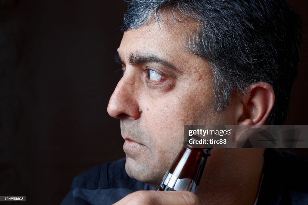 Mature asian man portrait holding beer bottle