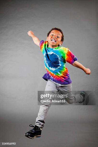 excited 8-year old mixed race boy jumping - tie dye stock pictures, royalty-free photos & images