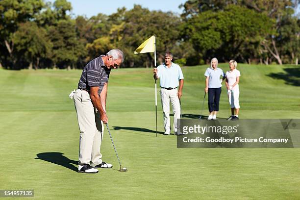 golfer on green putting the golf ball - golf putter stock pictures, royalty-free photos & images