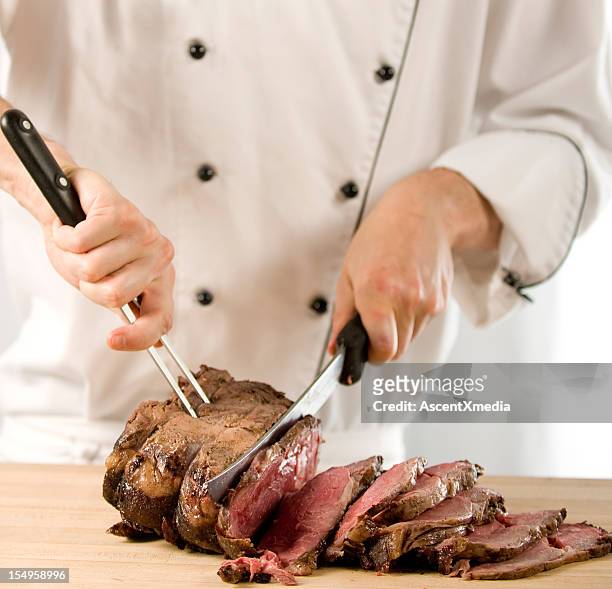chef carving perfectly cooked prime rib roast beef - carvery stockfoto's en -beelden