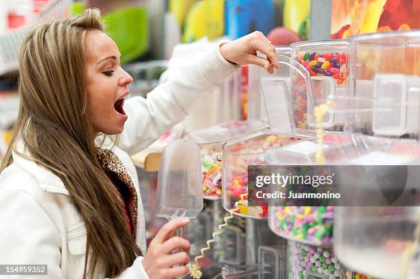 young woman shopping for candies - sweet shop stock pictures, royalty-free photos & images