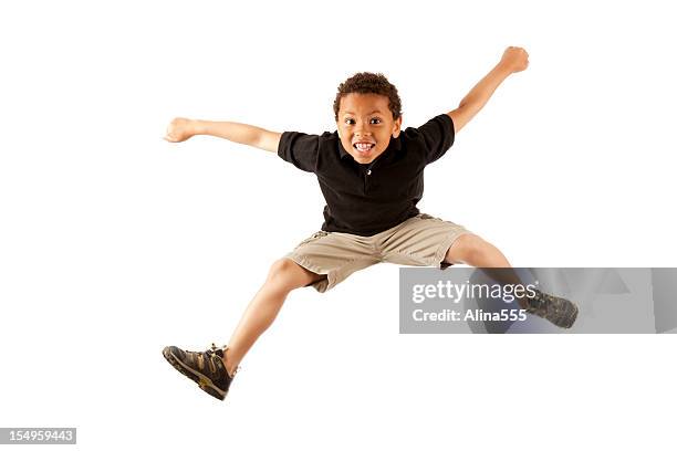 excited 8-year old mixed race boy jumping on white - kids excited stockfoto's en -beelden