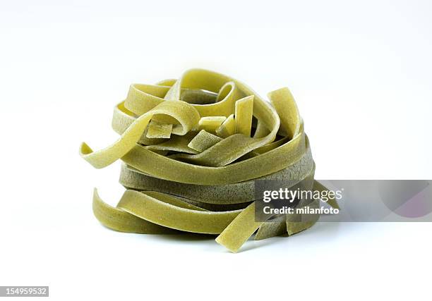 uncooked nido di pasta agli spinaci - pasta agli spinaci foto e immagini stock