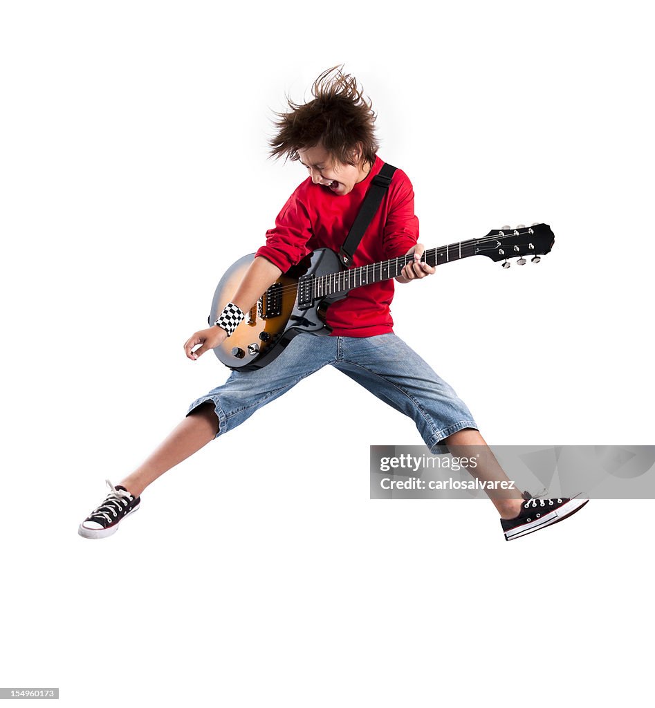 Kid playing the guitar while jumping in the air