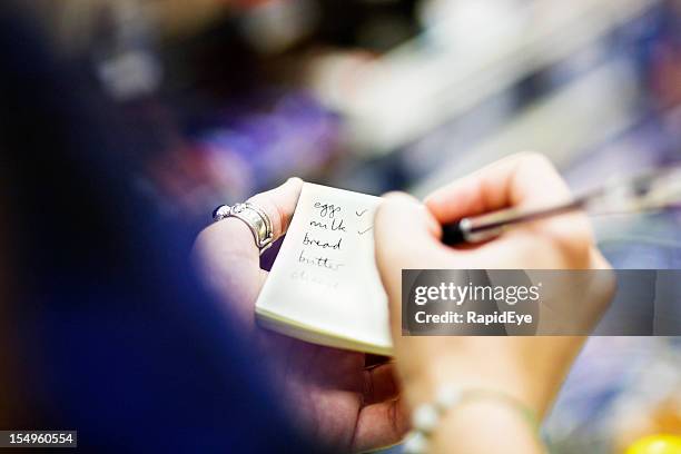 primo piano di donna le mani come controlli lista della spesa - lista della spesa foto e immagini stock
