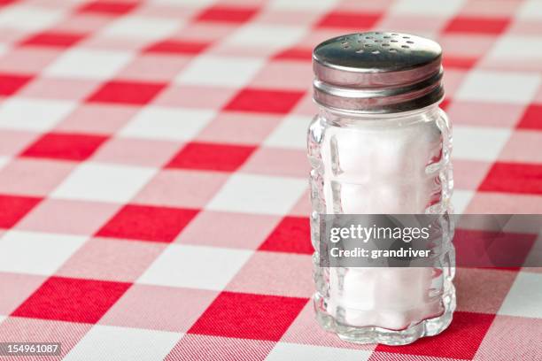 salt shaker on a red checkered tablecloth - salt cellar stock pictures, royalty-free photos & images