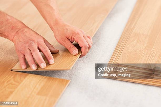 picture of man's hands laying yellow laminate flooring - implementation bildbanksfoton och bilder