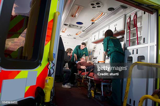 paramedics see to patient - ambulance uk stock pictures, royalty-free photos & images