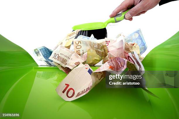 throwing money away with a dustpan brush - euros and trash stockfoto's en -beelden