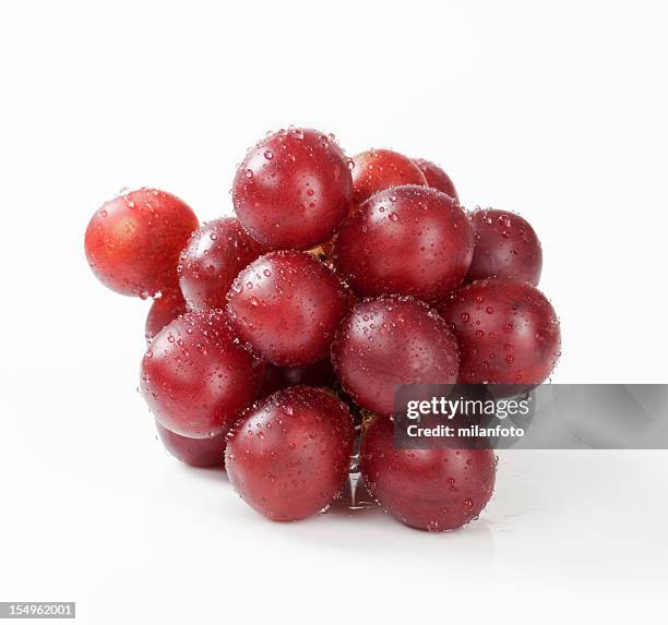 cluster of red grapes on a white background - red grape stockfoto's en -beelden