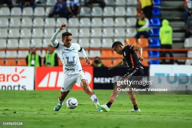 Adrián Aldrete of Pumas battles for the ball against Byron Castillo of Pachuca during the 3rd round match between Pachuca and Pumas UNAM as part of...