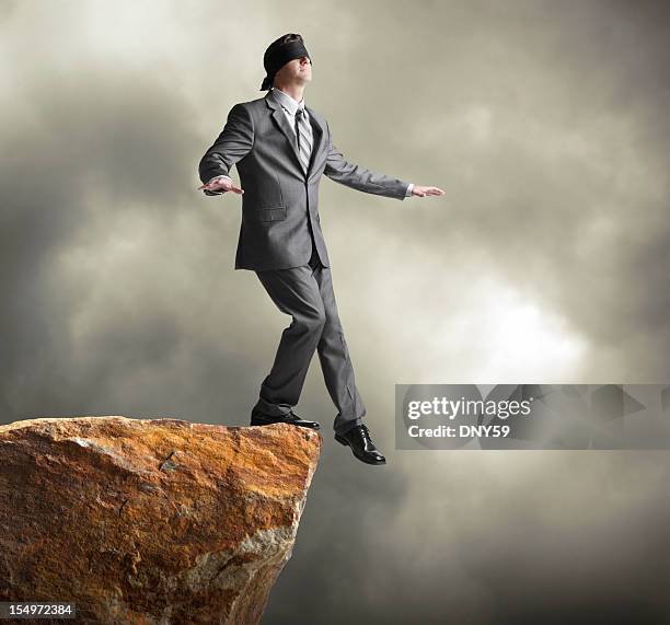 blindfolded businessman about to step off of a cliff - edge of a cliff stock pictures, royalty-free photos & images