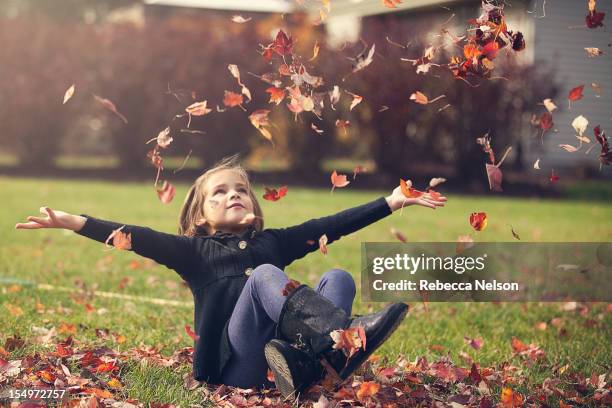 girl throwing atumn leaves - rebecca herbst stock-fotos und bilder