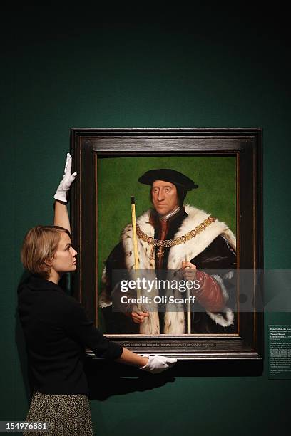 Woman adjusts a painting by Hans Holbein the Younger entitled 'Thomas Howard, Duke of Norfolk' in the exhibition 'The Northern Renaissance: Durer to...