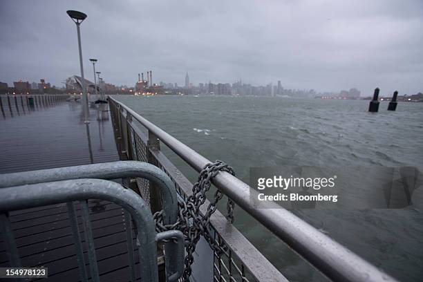 Barricades block foot traffic out to a pier over the East River in New York, U.S., on Monday, Oct. 29, 2012. Hurricane Sandy strengthened on its path...