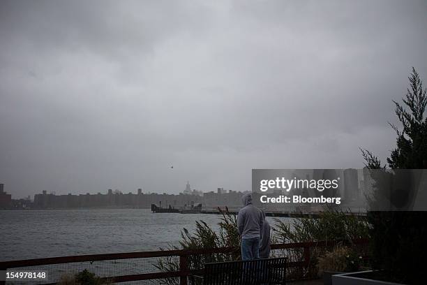 Onlookers watch as the storm gathers over Manhattan in New York, U.S., on Monday, Oct. 29, 2012. Hurricane Sandy strengthened on its path toward New...