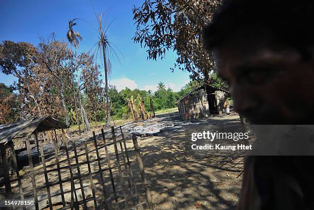 Muslim man walks past a burned house in Muslim quarter of Pa Rein village in Myauk Oo township, that was burned in recent violence between Buddhist...