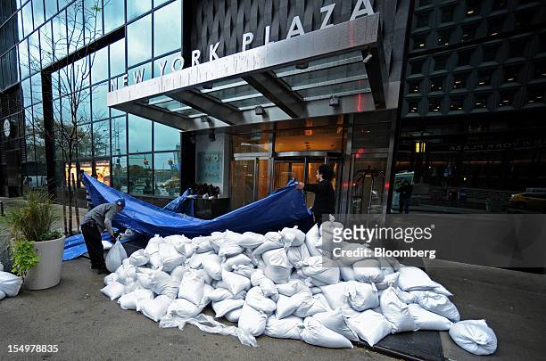 Workers stack sandbags at a building entrance on Water Street in preparation for Hurricane Sandy in New York, U.S., on Monday, Oct. 29, 2012....