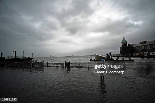 Woman takes a picture of a flooded area of Battery Park in New York, U.S., on Monday, Oct. 29, 2012. Hurricane Sandy, the Atlantic's largest-ever...