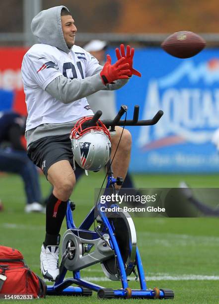 New England Patriots tight end Aaron Hernandez shows off his multi tasking ability as he catches a pass while warming up on a bicycle at today's...