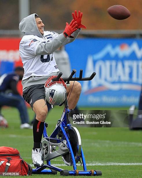 New England Patriots tight end Aaron Hernandez shows off his multi tasking ability as he catches a pass while warming up on a bicycle at today's...