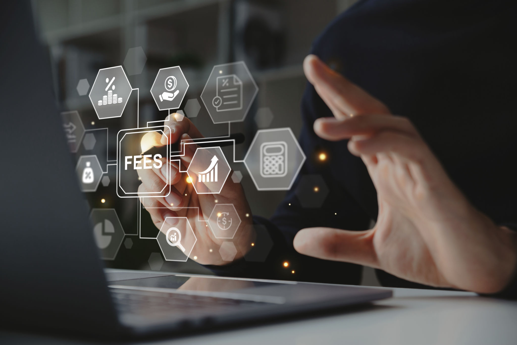 Hand of businessman holding a pen pointing to FEES on laptop screen. Hand of businessman holding a pen pointing to FEES on laptop screen.