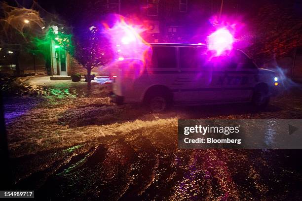 New York City Police Department vehicle drives through flood water in the Red Hook neighborhood of Brooklyn in New York, U.S., on Monday, Oct. 29,...