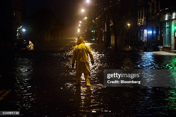 Walter Martiniano wades through a flooded street in the Red Hook neighborhood of Brooklyn in New York, U.S., on Monday, Oct. 29, 2012. Hurricane...