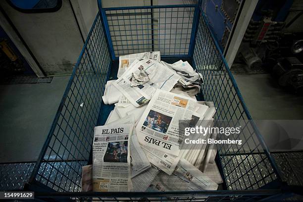 Trashed copies of recently printed El Pais newspapers lie in a basket at the El Pais printing plant in Madrid, Spain, on Tuesday, Oct. 30, 2012....