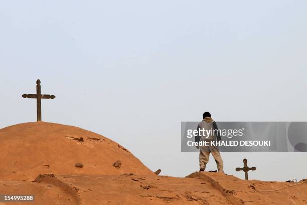 An Egyptian Coptic boy looks down from the roof of the Bishoy Monastery in Beheira province, 150 kms northwest of Cairo, on March 20 the final...