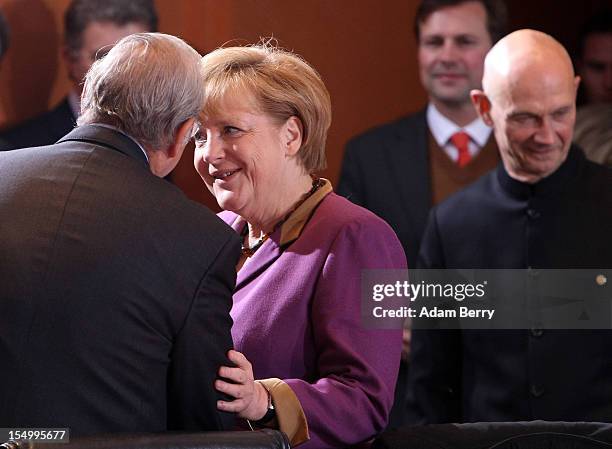 German Chancellor Angela Merkel greets Angel Gurria, secretary-general of the Organisation for Economic Co-operation and Development , next to Pascal...