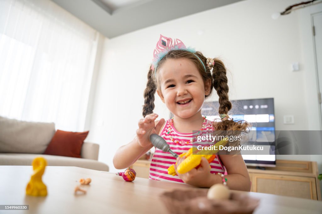 Hermosa niña jugando con juguete de dinosaurio de plástico
