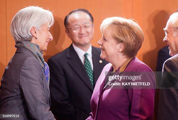 German Chancellor Angela Merkel welcomes Christine Lagarde , managing director of the International Monetary Fund , as World Bank chief Jim Yong Kim...