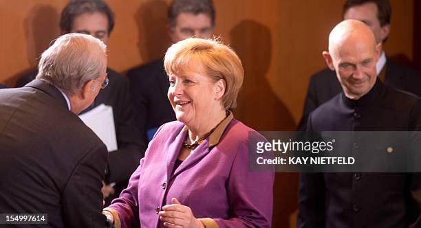 German Chancellor Angela Merkel welcomes OECD's chief Angel Gurria as Pascal Lamy , head of the World Trade Organization , looks on at the beginning...