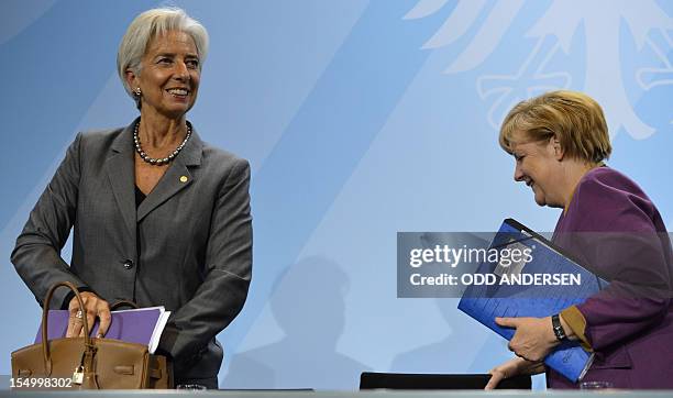 German Chancellor Angela Merkel and Christine Lagarde, managing director of the International Monetary Fund , leave after a press conference...