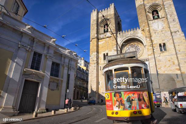 un tram giallo in strada, lisbona, portogallo - cattedrale della sé foto e immagini stock
